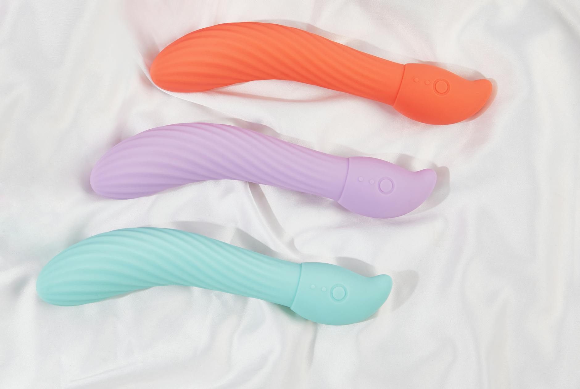 Three colorful lemon vibrators arranged on white fabric, symbolizing connection and shared pleasure.