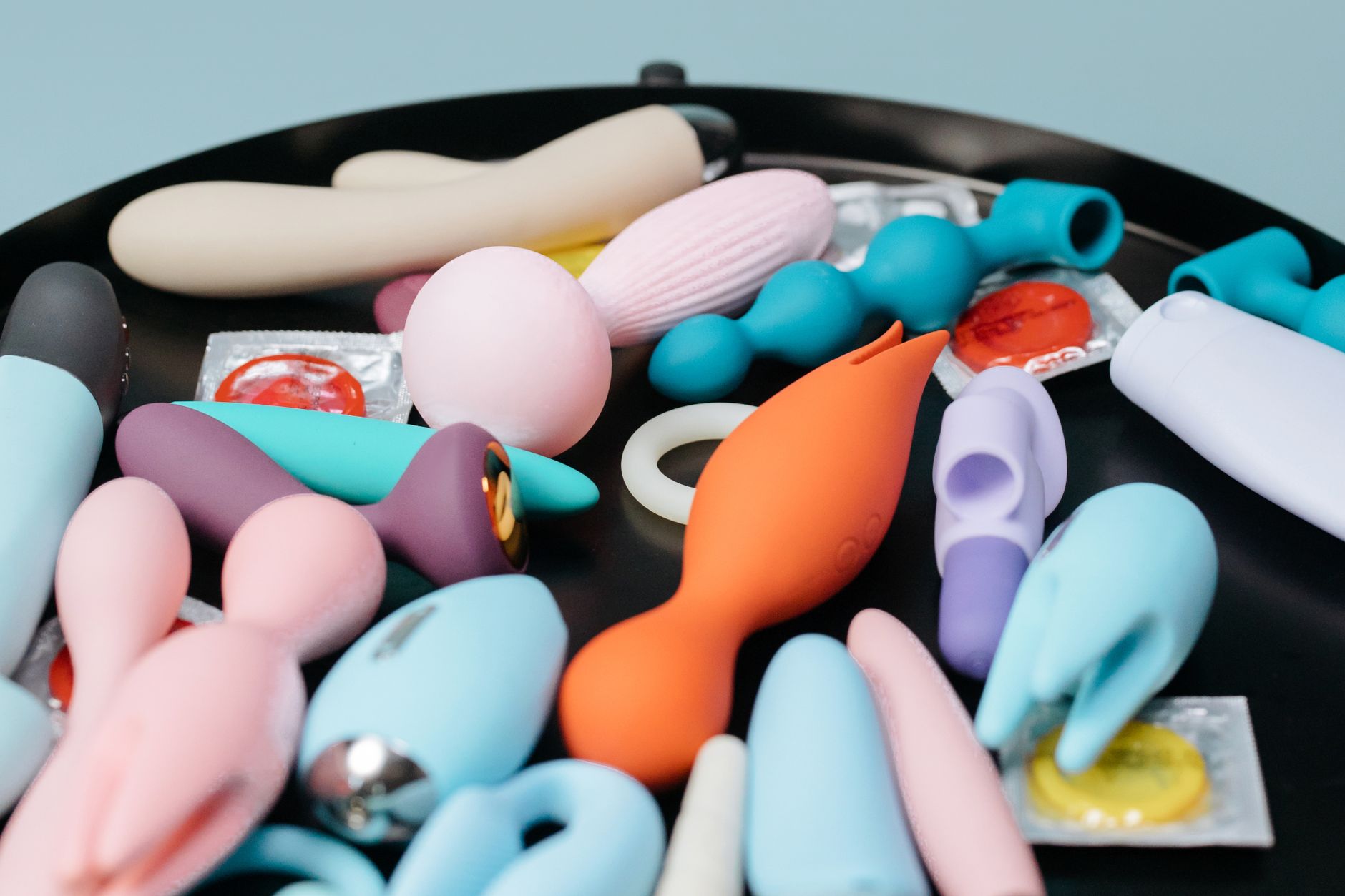 Hands holding vibrators, representing postpartum pleasure exploration