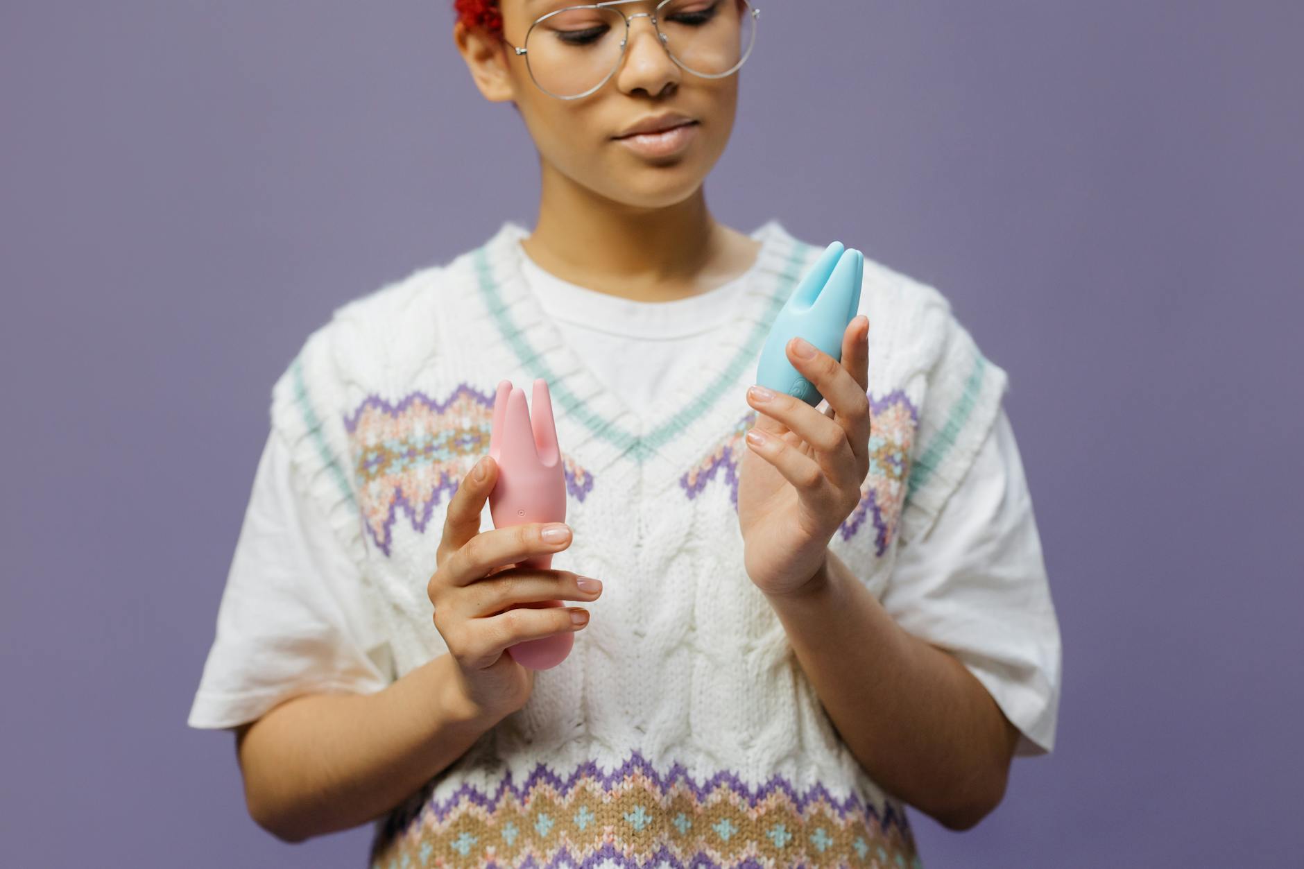 Woman holding colorful vibrators in a contemplative moment, representing modern approaches to long-term relationship intimacy.