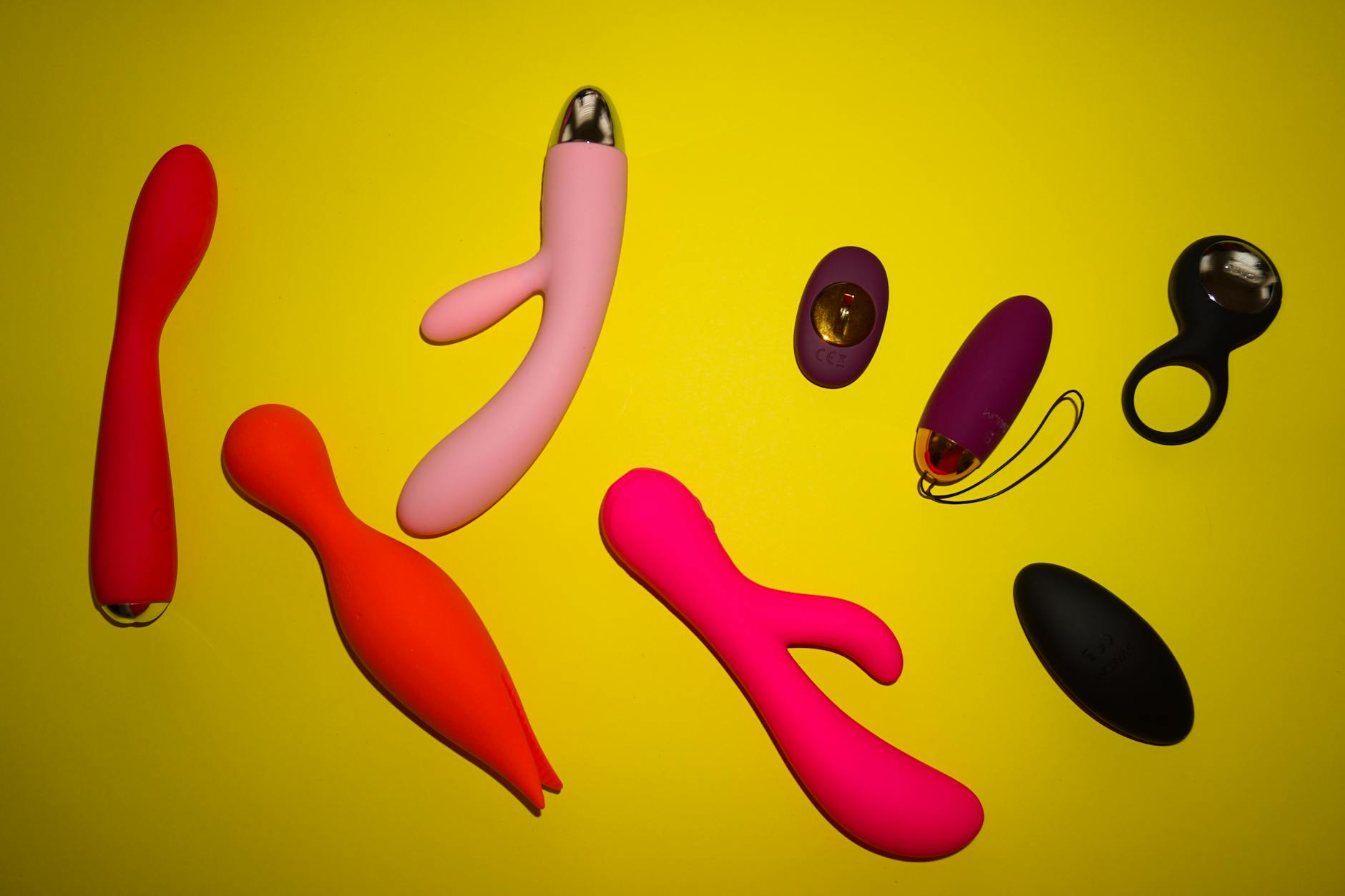 Woman holding colorful vibrators against a purple background
