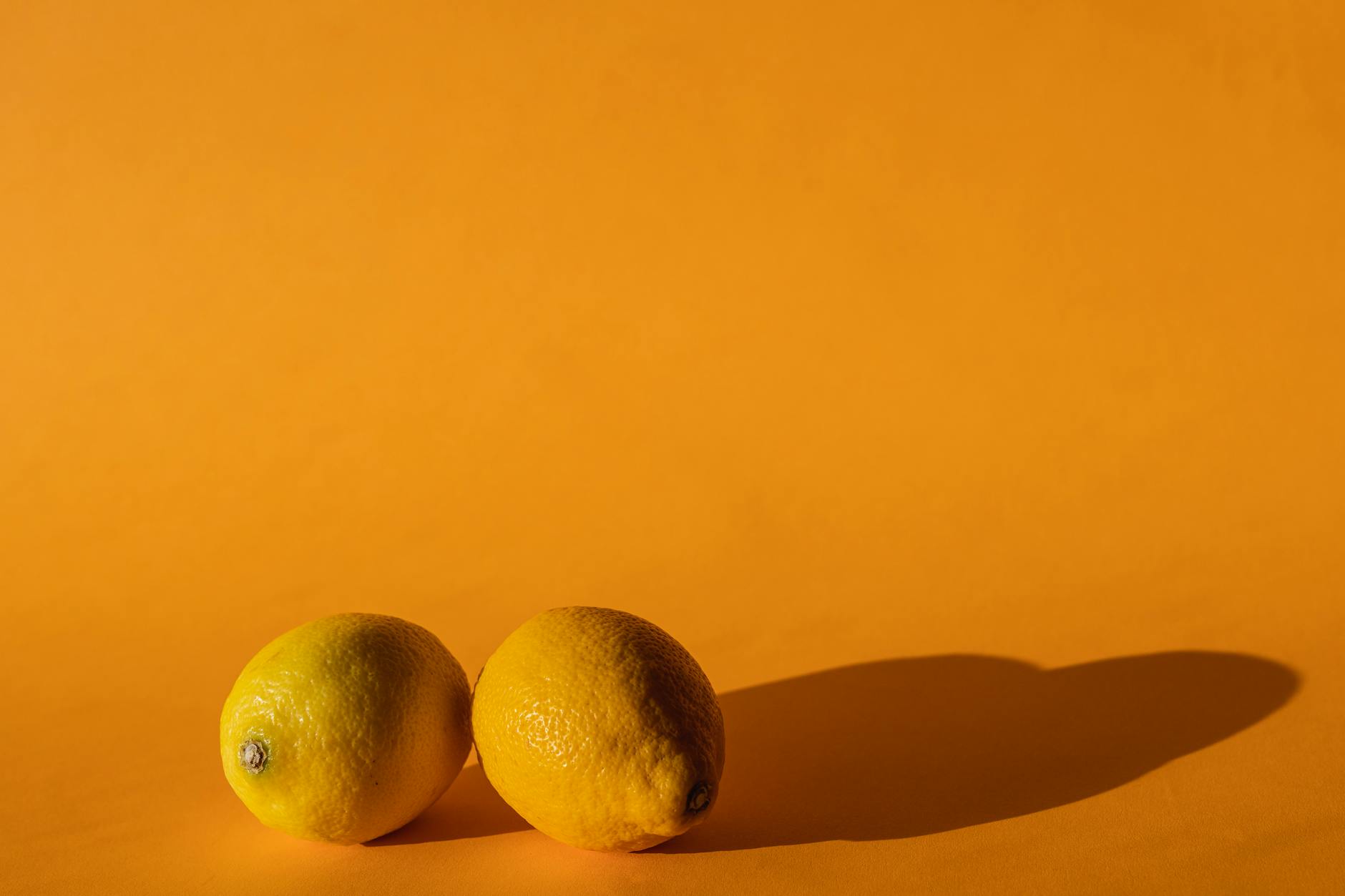 Vibrant fresh lemons on a bright yellow background, symbolizing hormonal shifts and sensory intensity